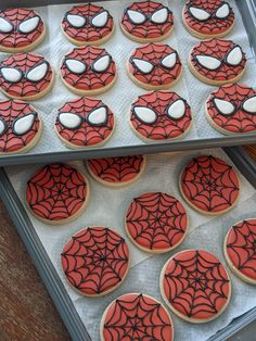 cookies decorated with spider - man's eyes and white frosting are on a tray