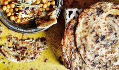 some food that is on top of a table next to a bowl of beans and bread