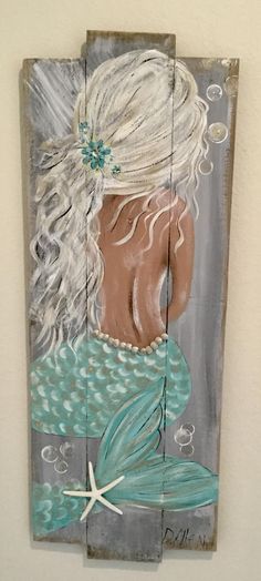 a wooden sign with a painting of a mermaid and starfish on it's side