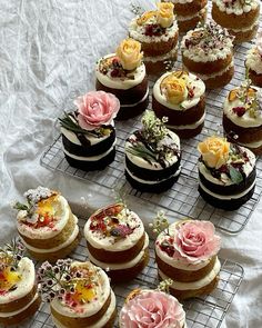 there are many different types of cupcakes on the rack together and one is decorated with flowers