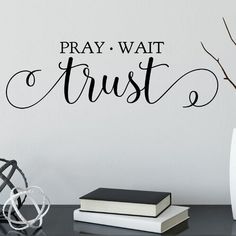 a wall decal that says pray wait trust