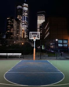 an empty basketball court in the city at night