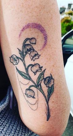 a close up of a person's leg with flowers on the side and a crescent