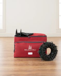 a red bag sitting on top of a hard wood floor next to a black blow dryer