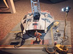 a star wars vehicle is on display in a room with other toys and equipment around it