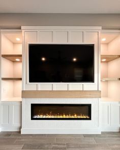 an entertainment center with built - in fireplace and flat screen tv mounted on the wall