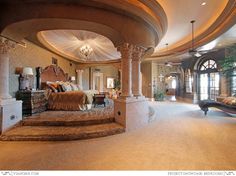 a large bedroom with an elaborate bed and chandelier in the middle of it