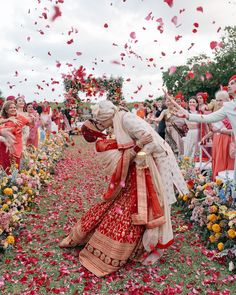 a bride and groom are surrounded by petals as they walk down the aisle to their wedding ceremony