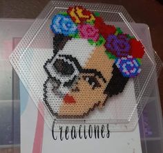 a beaded pin with a woman's face and flowers on it, in a clear plastic case