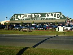 a store front with cars parked in the lot and on the side of the road