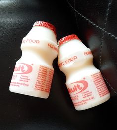 two plastic bottles sitting on top of a black surface