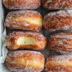 a box filled with lots of sugar covered doughnuts