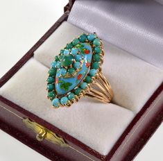 Eye catching custom made 14K gold cocktail ring embellished with Persian turquoise and polychrome enamel. The size of the ring is 6.5. The oval 4-tier face of the ring designed as a sophisticated crown supporting oval dome surrounded by Persian turquoise cabochons. The dome covered with beautiful enamel matching the color to natural turquoise cabochons. Red and green translucent enamel flower and berries, and leaves are scattered on the dome. A smaller coronet with turquoise cabochons on the top Collectible Hallmarked Enamel Ring In Fine Jewelry Style, Oval Turquoise Enamel Jewelry, Turquoise Oval Enamel Jewelry, Oval Cabochon Enamel Ring Collectible, Fine Jewelry Enamel Multi-stone Ring Gift, Turquoise Enamel Rings Ideal For Gifts, Turquoise Enamel Rings As A Gift, Turquoise Enamel Rings For Gift, Luxury Multi-stone Enamel Ring As Gift