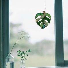 a window sill with vases and plants in front of it