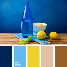 a bottle of water and two lemons on a table with color swatches in the background