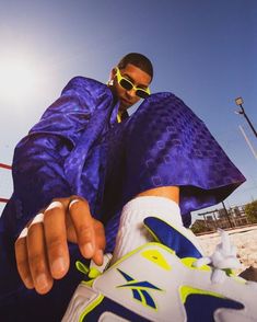 a man wearing sunglasses and a purple cape