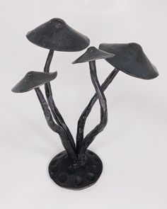 three metal mushrooms sitting on top of a black base