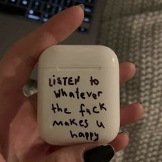 a hand holding an airpods with writing on it that says listen to whatever the f k makes u happy