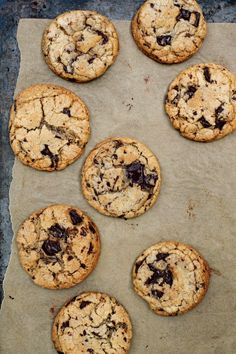 nine cookies sitting on top of a cookie sheet covered in chocolate chips and crumbs