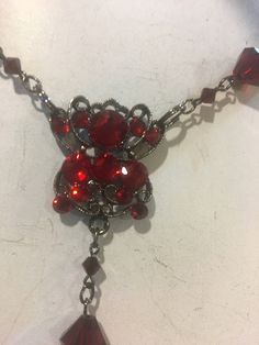 This is a beautiful red long necklace that can be adjusted and used multi ways. Wrap it around your neck for a choker look or adjust it to fit however you wish. Ruby red crystal beads plated in black . Cross has crystals on both sides. Red Gothic Jewelry For Party, Red Choker Necklaces For Formal Occasions, Red Ruby Choker Necklace, Red Choker Necklace For Formal Occasions, Red Gothic Necklace For Formal Occasions, Formal Red Choker Necklaces, Formal Red Choker Necklace, Red Metal Choker For Party, Elegant Red Crystal Pendant Necklace