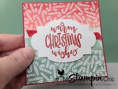 someone holding up a christmas card with the words warm christmas wishes written in red and green