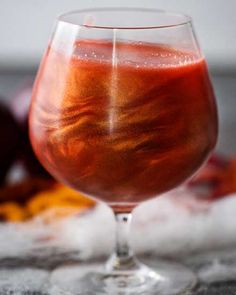 a glass filled with liquid sitting on top of a table