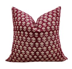 a red and white pillow with gold leaves on the front, sitting on a white background