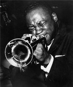 a man is playing the trumpet in black and white photo, with his eyes closed