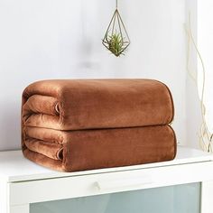 two brown towels sitting on top of a white shelf