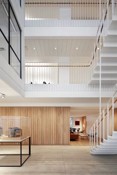 there is a man walking in the middle of this room with wooden floors and white balconies