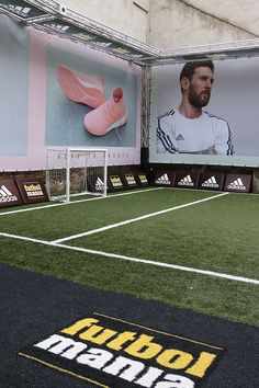 an indoor soccer field with posters on the wall