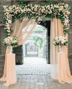 an archway decorated with flowers and greenery