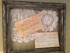 an old frame with doily and paper pinned to it