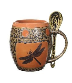 an orange and black dragonfly mug with a spoon in the middle, on a white background