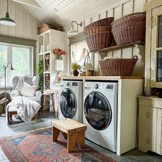 a washer and dryer in a small room with baskets on the wall above