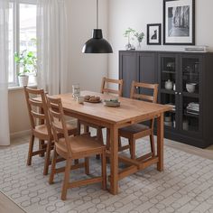 a dining room table and chairs in front of a window