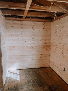 an empty room with wooden walls and wood flooring