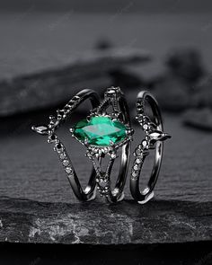 two rings with an emerald stone in the middle