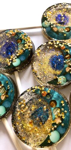 four blue and gold decorated plates on top of a white tablecloth with pins in it