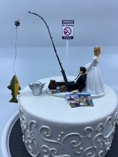 a wedding cake with a fishing theme on top and a sign that says no fishing allowed