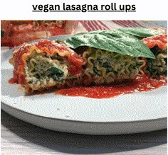 a white plate topped with veggie lasagna roll ups covered in sauce