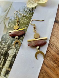 These are beaded, boho-style, mini crescent moon statement earrings featuring genuine red jasper rice beads, dalmatian jasper, and brass geometric pendants and connectors.These unique statement earrings hang approximately 2.25" inches from the lobe and measure about 1.0" inches across their widest point. They feature an 18k gold plated fishhook closure. These earrings are lightweight and should be suitable for everyday wear.Please see my other listings for all styles within this collection. Bohemian Jasper Dangle Jewelry, Nickel Free Jasper Bohemian Jewelry, Nickel-free Bohemian Jasper Jewelry, Bohemian Jasper Jewelry Nickel Free, Jasper Dangle Earrings With Ear Wire, Earthy Earrings, Beach Jewelry Boho, Bold Statement Jewelry, Earring Inspiration