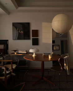 a living room filled with furniture and a lamp hanging from the ceiling next to a table