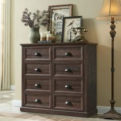 a wooden dresser sitting next to a lamp in a room