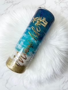 a blue and gold water bottle sitting on top of a white fur covered floor