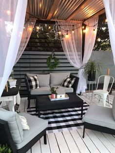 an outdoor living area with black and white furniture