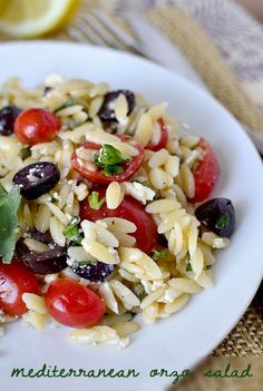 a white plate topped with pasta salad and olives