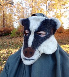 Immerse yourself in the wild with this felt badger mask for adults. Crafted with meticulous attention to detail, this unisex mask captures the distinctive features of a badger, from its striking black and white markings to its pointed snout. Put it on and let your imagination run wild, whether you're attending a costume party, exploring nature trails, or simply adding a little whimsy to your everyday life. The soft felt material ensures a comfortable fit that won't restrict your vision or breath Animal Costume Mask, Mask Theater, Forest Spirit Mask, Animal Masquerade Mask, Felt Badger, Wood Masks Bear, Creepy Animal Mask, Festival Headdress, Mask Photoshoot