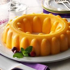 a bundt cake on a plate with grapes and mint