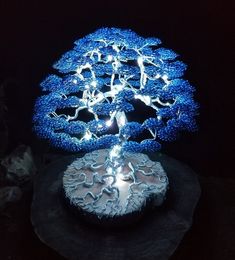 a blue tree is lit up in the dark